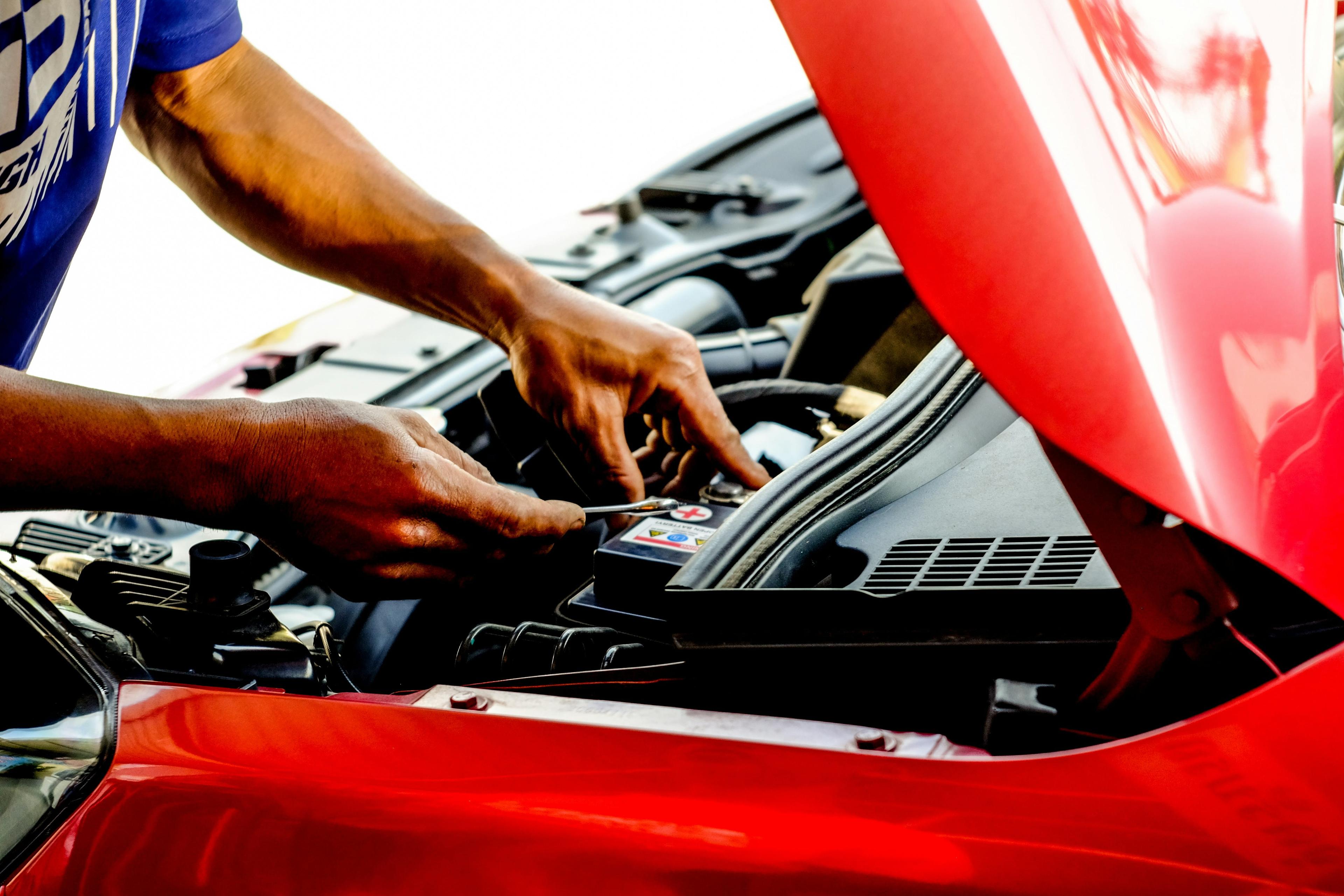 Technician jump starting a car with booster cables in JLT, Dubai